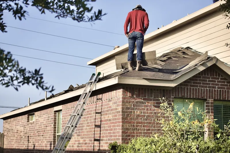 Professional roofer working on a residential roof in Bedford